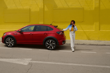 ragazza-al-telefono-appoggiata-su-auto-volkswagen-rossa