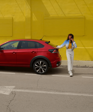 ragazza-al-telefono-appoggiata-su-auto-volkswagen-rossa